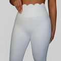 Professional white scalloped leggings on grey background